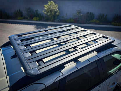 Galerie de toit Pioneer 1300x1240mm pour Dacia Duster 2024+ de la marque Rhino-Rack, vue de face sur le véhicule.